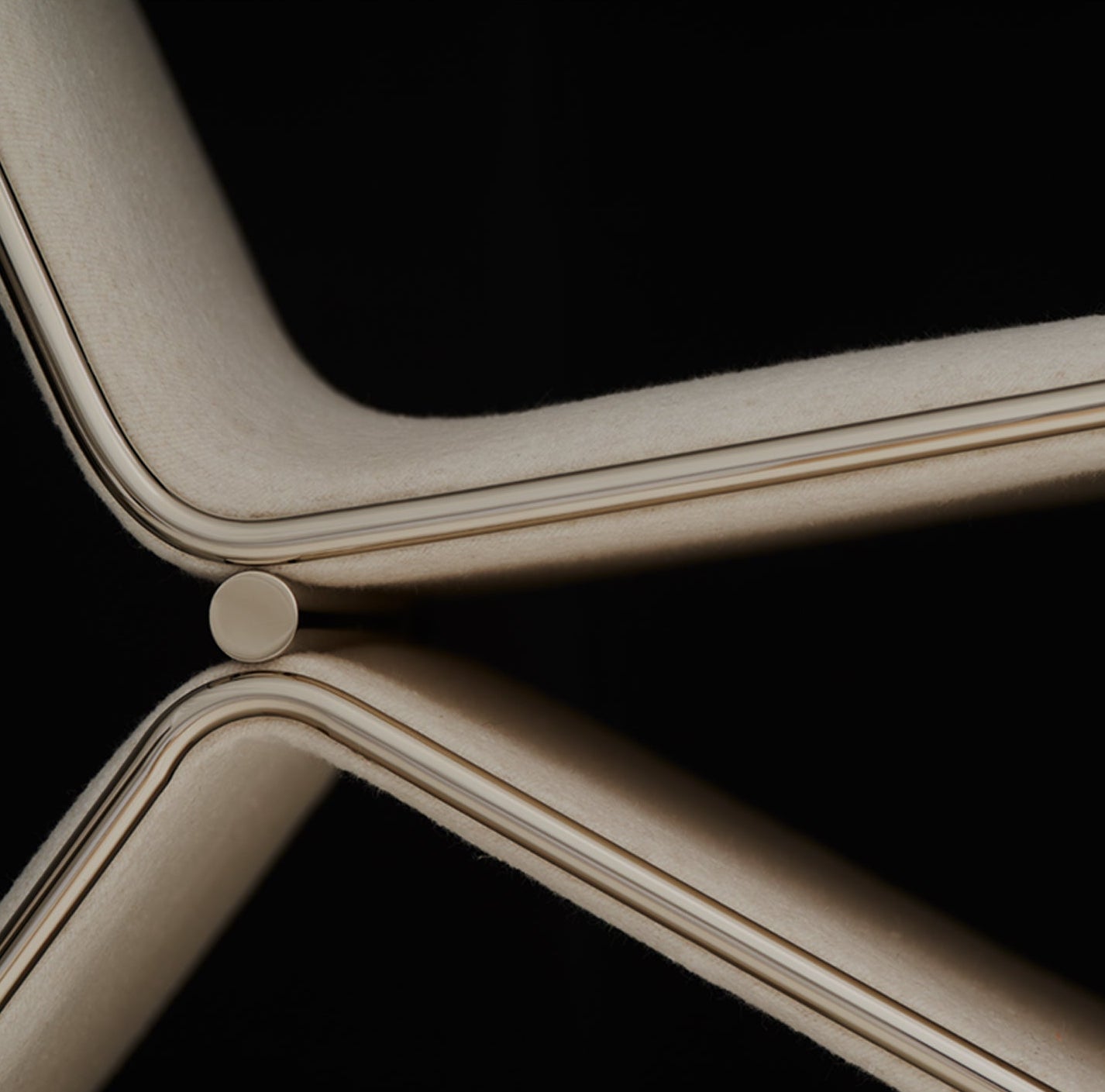 Close-up of a metallic chair frame on a black background